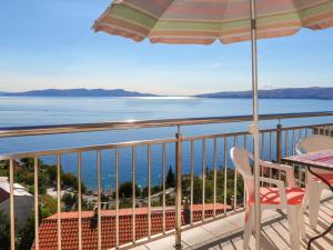 a balcony with a table and an umbrella and the ocean at Apartment Ivana by Interhome in Senj