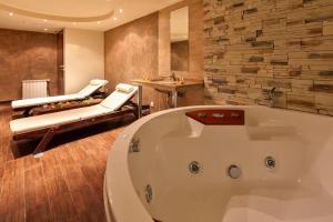 a bathroom with a bath tub and two chairs at TERRA COMPLEX D4 - Private apartment - Golf, Skiing & SPA in Bansko