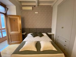 a bedroom with a large bed with two pillows at Condotti Rooms in Rome