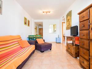 1 dormitorio con 1 cama, TV y sofá en Apartment Las Dunas by Interhome, en Moncófar