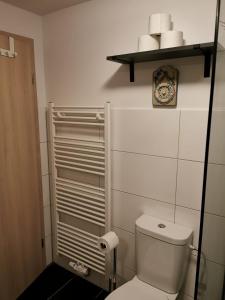 a bathroom with a toilet and a shelf with towels at Mansarde Ferienwohnung - Modern - Zentral - PayTV in Wilhelmshaven