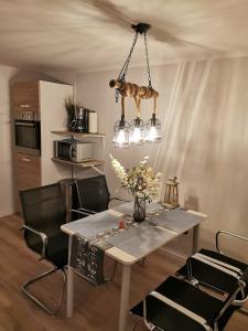 a dining room with a table and a chandelier at Mansarde Ferienwohnung - Modern - Zentral - PayTV in Wilhelmshaven