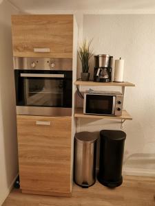 a kitchen with a microwave oven and a counter with at Mansarde Ferienwohnung - Modern - Zentral - PayTV in Wilhelmshaven