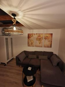ein Wohnzimmer mit Sofa und Karten an der Wand in der Unterkunft Mansarde Ferienwohnung - Modern - Zentral - PayTV in Wilhelmshaven