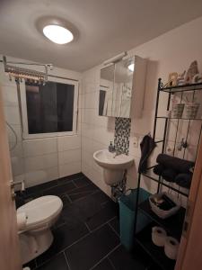 ヴィルヘルムスハーフェンにあるMansarde Ferienwohnung - Modern - Zentral - PayTVの白いトイレと洗面台のあるバスルーム +7枚の写真