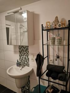 ヴィルヘルムスハーフェンにあるMansarde Ferienwohnung - Modern - Zentral - PayTVの洗面台と鏡のあるバスルーム