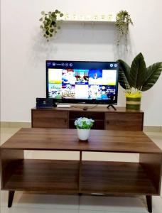 a desk with a computer monitor on top of a table at Desaru Cozy Home, 11pax, Beach ,Waterpark, Wifi, BBQ in Bandar Penawar