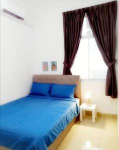 Un dormitorio con una cama azul y una ventana en Desaru Sweet and Cozy Home,11pax, Mini Pool, Beach ,Waterpark, Wifi, BBQ, en Bandar Penawar