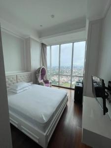 Habitación de hotel con cama y ventana grande en City Penthouse with Jakarta Skyline, en Yakarta