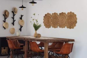 a wooden table with chairs and a vase on it at Finca El Jaral in Santa Elena