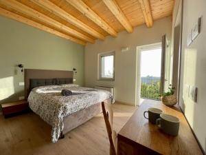 a bedroom with a bed and a table and a window at Corte Baccoi in Rovere Veronese
