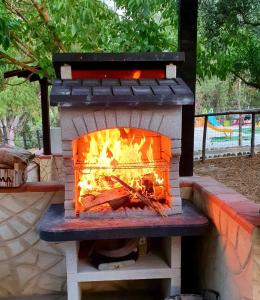 um forno de tijolos com um fogo dentro dele em Villa Parco Morello Piano Terra em Villarosa