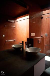 - deux lavabos sur un comptoir dans la salle de bains dans l'établissement Uravu Bamboo Grove Resort, à Wayanad