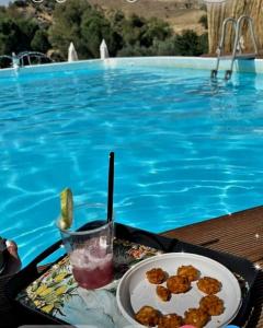 uma mesa com um prato de comida ao lado de uma piscina em Villa Parco Morello Piano Terra em Villarosa