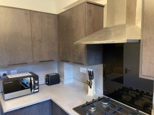 a kitchen with a stove and a microwave at Serviced Accommodation 2 bed house III in Hindlip