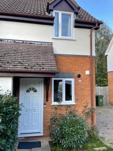a house with a white door and a window at Serviced Accommodation 2 bed house III in Hindlip