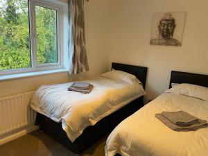 two beds in a room with a window at Serviced Accommodation 2 bed house III in Hindlip