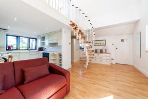 a living room with a red couch and a kitchen at 83 Downs Hill in Beckenham