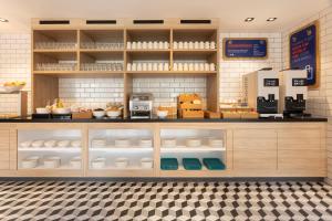 a kitchen with a counter with white dishes on display at Holiday Inn Express & Suites - Deventer, an IHG Hotel in Deventer