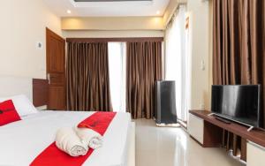 una camera con letto e TV a schermo piatto di RedDoorz Syariah @ Batua Raya a Makassar