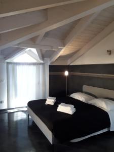 a bedroom with a black bed with towels on it at Residence Ki House in Parma +82 photos