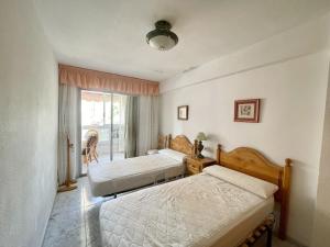 sypialnia z dwoma łóżkami i oknem w obiekcie Lepanto Pool and Fun w mieście Benidorm +16 zdjęć