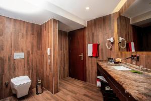 a bathroom with wooden walls and a toilet and a sink at Manaspark Deluxe Hotel in Oludeniz
