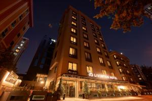 a tall building with a sign on it at night at Livinton İstanbul Ataşehir in Istanbul
