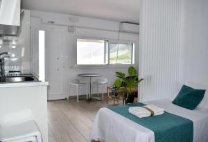 a white room with a bed and a kitchen at Casa Sabare in Guinea
