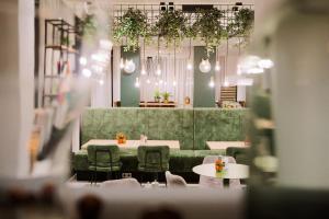 a restaurant with tables and chairs and a green wall at Aparthotel Adagio Access Freiburg in Freiburg im Breisgau