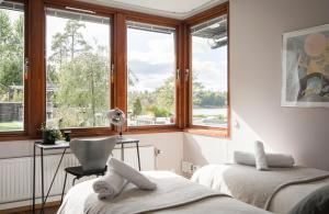 Habitación con 2 camas, escritorio y ventana. en Exclusive Lakefront Mansion with pools in Stockholm en Tyresö