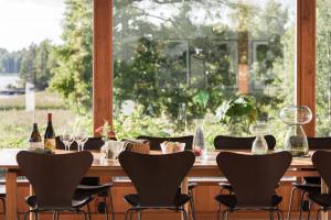 een houten tafel met stoelen en wijnglazen bij Exclusive Lakefront Mansion with pools in Stockholm in Tyresö