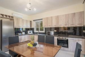 a kitchen with a table with a bowl of fruit on it at Afroditi Holiday Home- Green View Apartment in Svoronata +14 photos