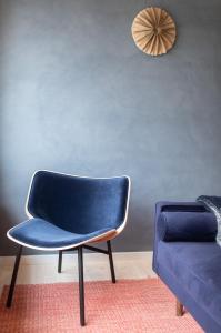 una silla azul sentada junto a un sofá azul en Villa Huno, en Borre