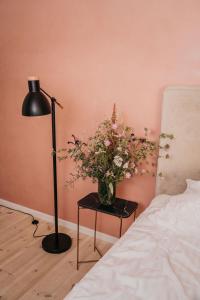 a vase of flowers on a table next to a bed at Villa Huno in Borre