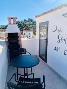einen Tisch und Stühle auf einer Terrasse mit Aussicht in der Unterkunft Bodegas de Felicidad in Setenil de las Bodegas