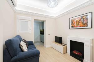salon z niebieską kanapą i telewizorem w obiekcie Reformado decorado céntrico 1 dormitorio w Madrycie