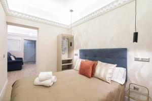 sypialnia z dużym łóżkiem z niebieskim zagłówkiem w obiekcie Reformado decorado céntrico 1 dormitorio w Madrycie