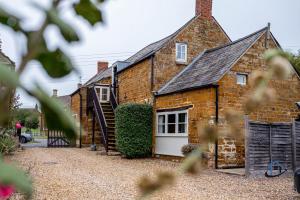 an old brick house with a white door at The Old Plough, rustic flat, super king bed or twins, en-suite, secure parking, free wi-fi, corporates welcome in Caldecott