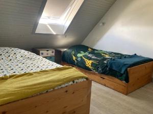 a bedroom with two twin beds and a skylight at Les pieds dans le sable in Roscoff