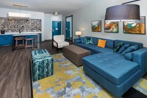 a living room with a blue couch and a kitchen at Hotel Indigo Spring - Woodlands Area, an IHG Hotel in Spring