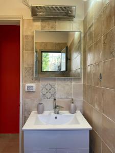 a bathroom with a sink and a mirror at Alma BaHar - charming 2 bdrm house with garden עלמה בהר - דירת אירוח בלב גן פורח in Zikhron Ya‘aqov