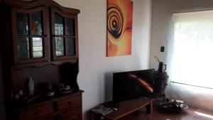 a living room with a flat screen tv and a dresser at casa de campo a 40 km de Rosario in Villa Amelia