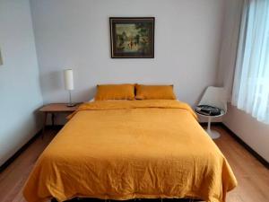 a bedroom with a large bed with a yellow bedspread at Seahaven in Lake Tyers