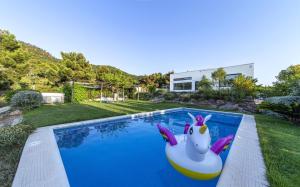 a swimming pool with a unicorn float in a backyard at Villa Marmudella in Puebla Tornesa