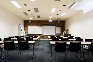 an empty lecture room with tables and chairs at Clarion Collection Hotel Cardinal in Växjö