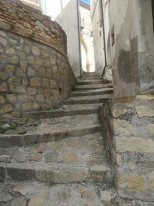 una escalera de piedra que conduce a una pared de piedra en Il Pittore - Guest House, en Valsinni