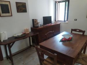 comedor con mesa de madera y escritorio en Il Pittore - Guest House, en Valsinni
