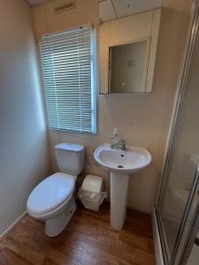 a bathroom with a toilet and a sink at Bittern 8, Scratby - California Cliffs, Parkdean, sleeps 8, free Wi-Fi, pet friendly - 2 minutes from the beach! in Scratby