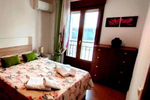 sypialnia z łóżkiem z zielonymi poduszkami w obiekcie Apartamento en zona de ocio casco antiguo w Alicante